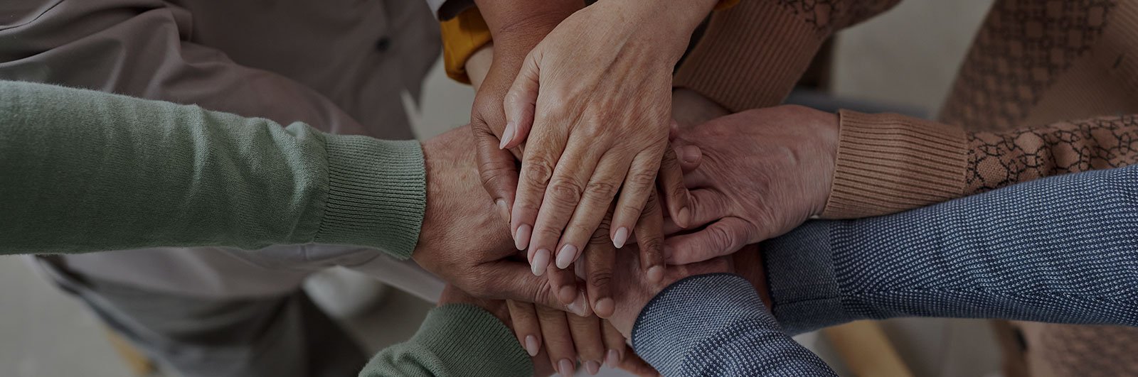 Senior hands stacked in a circle